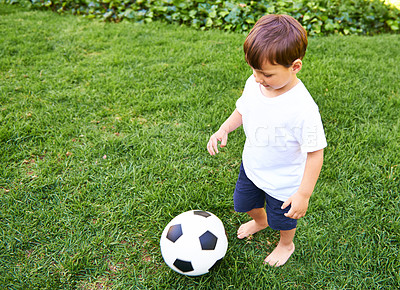 Buy stock photo Confident boy, kick and football in garden for exercise, fun game and fresh air in South Africa. Sweet, adorable and happy male child with soccer ball for healthy, recreation or childhood development