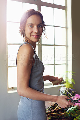 Buy stock photo Shot of a beautiful woman completing a floral bouquet on a wooden counter top