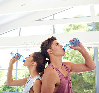 Buy stock photo Cropped shot of a young couple standing back-to-back in sportswear