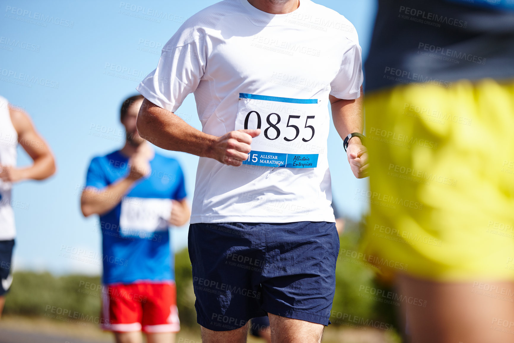 Buy stock photo Cropped shot of a group of men running a marathon