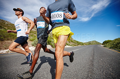 Buy stock photo Shot of a group of men running a road race