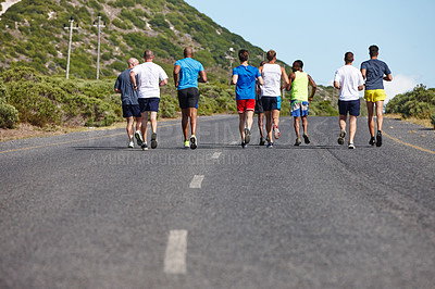 Buy stock photo Rearview shot of a group of men running a marathon