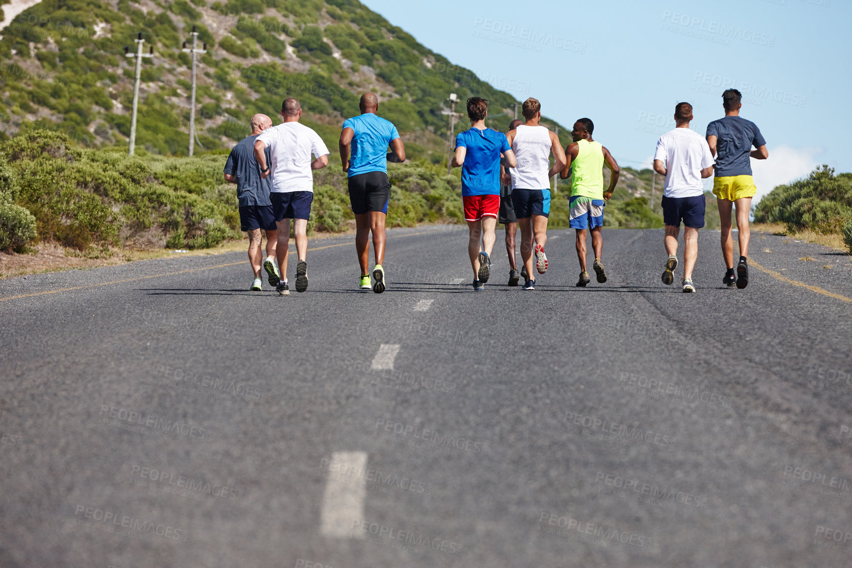 Buy stock photo Rearview shot of a group of men running a marathon