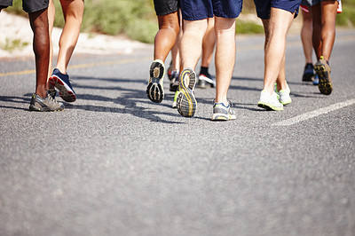 Buy stock photo Shot of the legs of a group of men running a road race