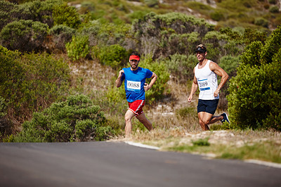 Buy stock photo Shot of two young men running a marathon