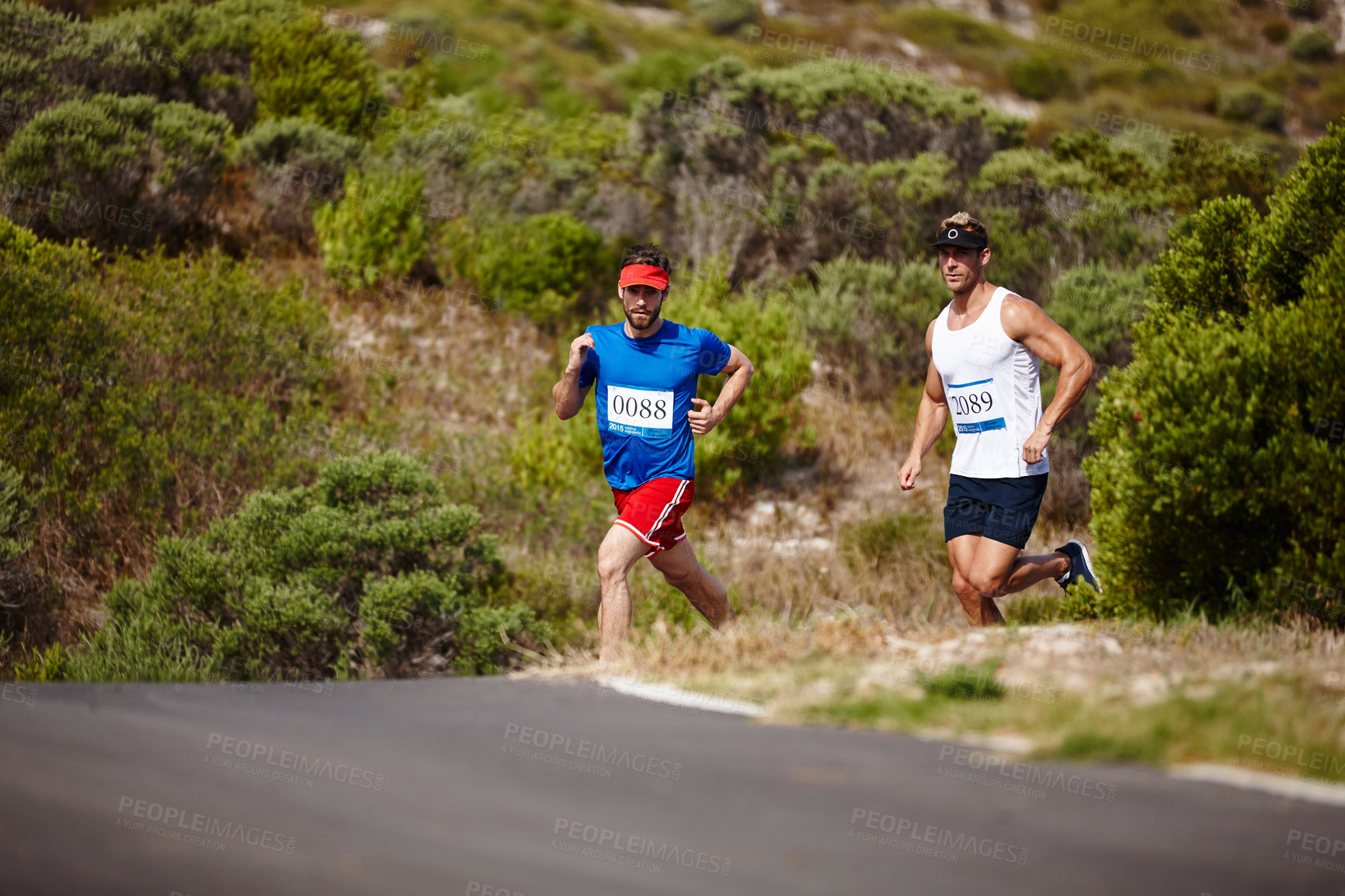 Buy stock photo Shot of two young men running a marathon