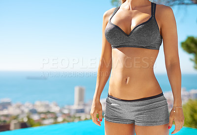 Buy stock photo Cropped shot of a woman with a toned body standing beside a swimming pool