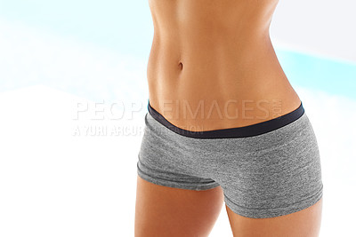 Buy stock photo Cropped shot of a woman with a toned stomach posing outdoors in sportswear