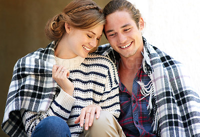 Buy stock photo Cropped shot of a young couple wrapped in a blanket together