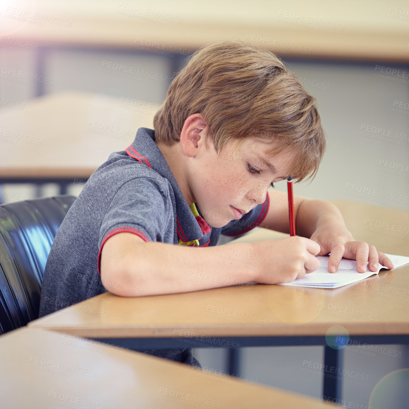 Buy stock photo Child, student and writing in classroom for learning, education and development in language quiz or test. Smart boy or kid with notebook for school progress, creativity and knowledge at his desk