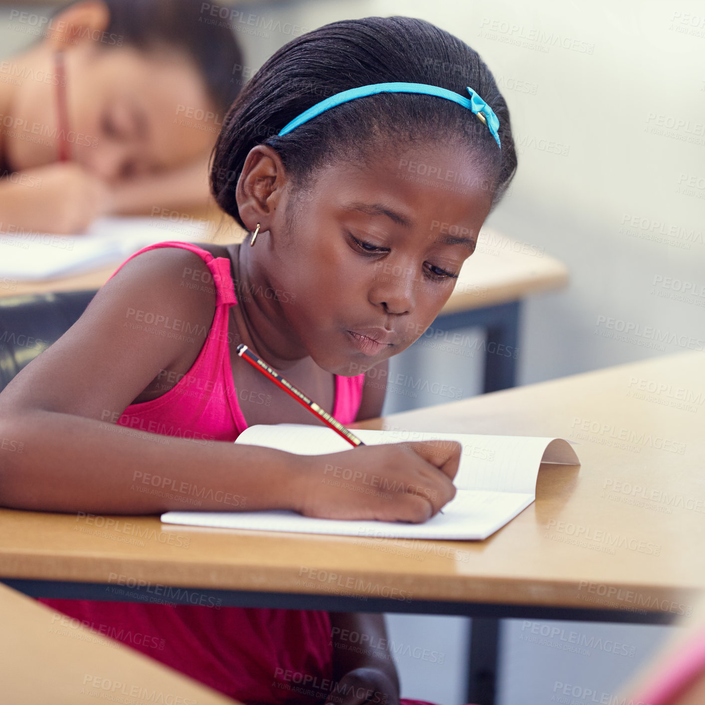 Buy stock photo Black girl, school or writing in classroom with notebook, studying lesson or learning academic assessment at desk. Student, child or kid drawing on paper in educational development, test or knowledge