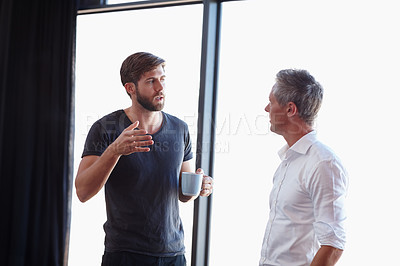 Buy stock photo Shot of two handsome businessmen having a discussion in the office