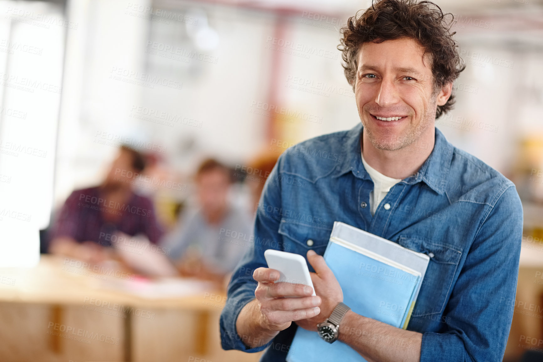 Buy stock photo Shot of a handsome businessman using a mobile phone in a casual office