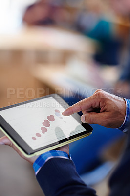 Buy stock photo Cropped shot of a man looking at graphs on a digital tablet in an office