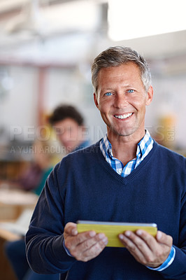 Buy stock photo Portrait of a handsome businessman holding a digital tablet in a casual office