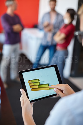 Buy stock photo Over the shoulder shot of a female designer looking at graphs on a digital tablet