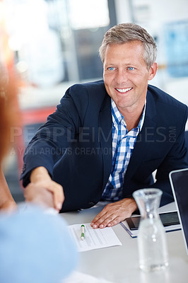 Buy stock photo A mature businessman shaking hands with an employee