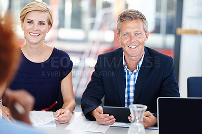 Buy stock photo A mature male manager sitting in a meeting with his team