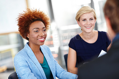 Buy stock photo Cropped shot of a young female designer in an informal meeting with her colleagues