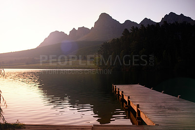 Buy stock photo A pier leading to a tranquil lake