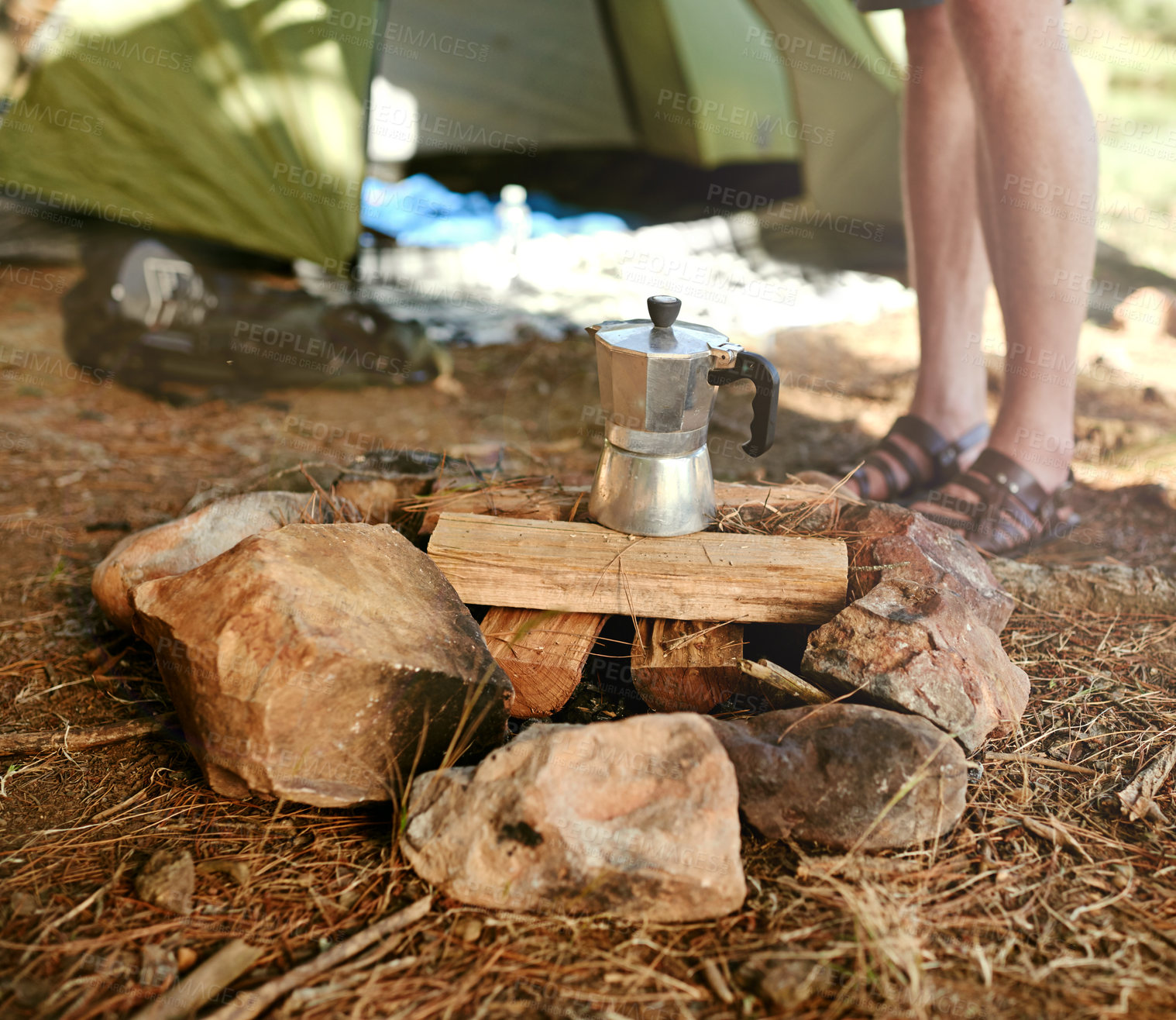 Buy stock photo Shot of a camper preparing to make coffee on a campfire