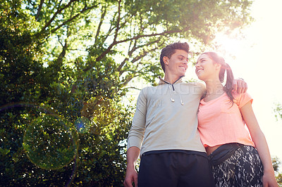 Buy stock photo Shot of a sporty young couple walking together in nature