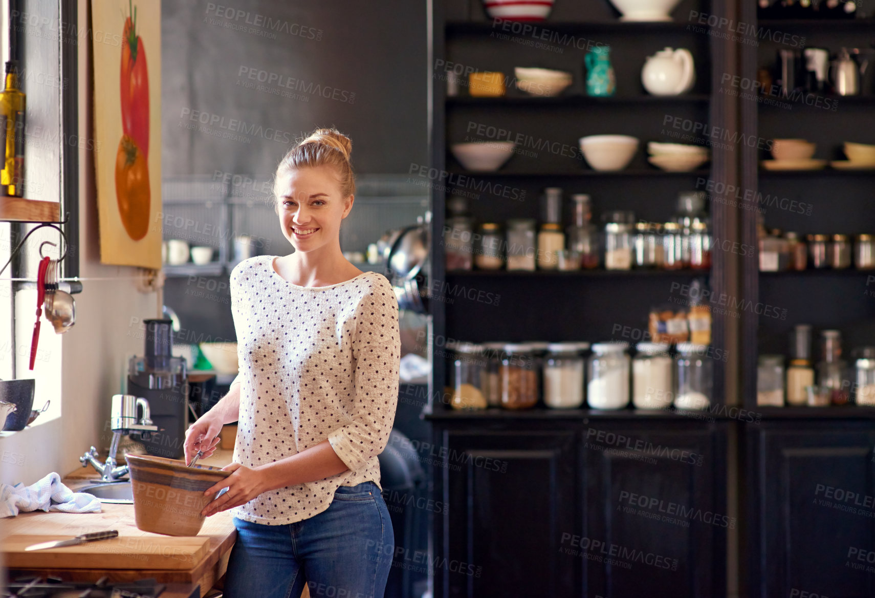 Buy stock photo Shot of a beautiful young woman preparing food in her kitchen