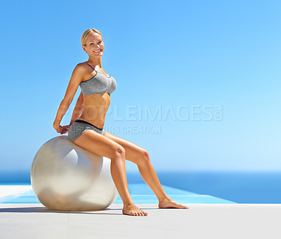 Buy stock photo Portrait of an attractive young woman working out with an exercise ball by a swimming pool