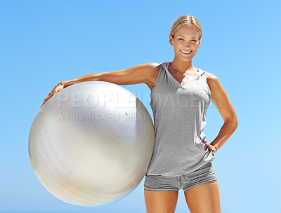 Buy stock photo Portrait of fit young woman holding an exercise ball against a blue sky