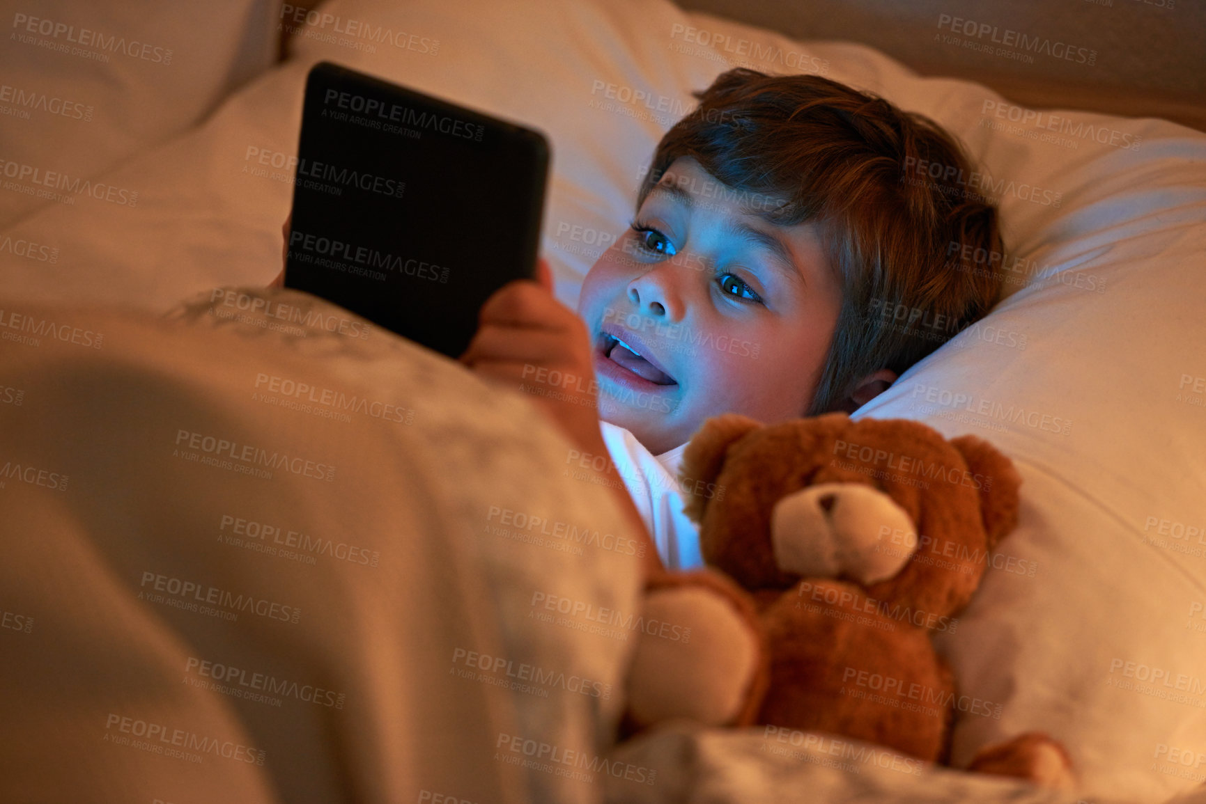 Buy stock photo Boy, kid and tablet in bed at night with smile, reading or online game with app in family home. Child, bedroom and digital touchscreen for movie, cartoon and streaming subscription to relax in house