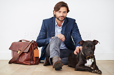 Buy stock photo Shot of a handsome man spending time with his dog after a day at the office