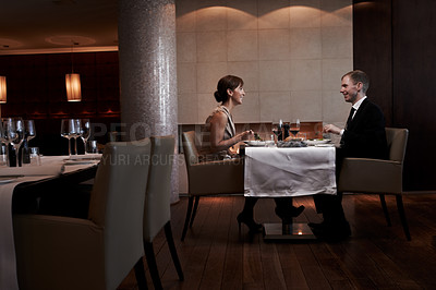 Buy stock photo Cropped shot of a couple having dinner in a restaurant