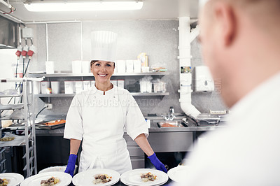 Buy stock photo Chef, woman and kitchen with cooking staff, restaurant and gourmet meal prep and serving. Smile, catering service and culinary skills, nutrition and working in hospitality industry for fine dining