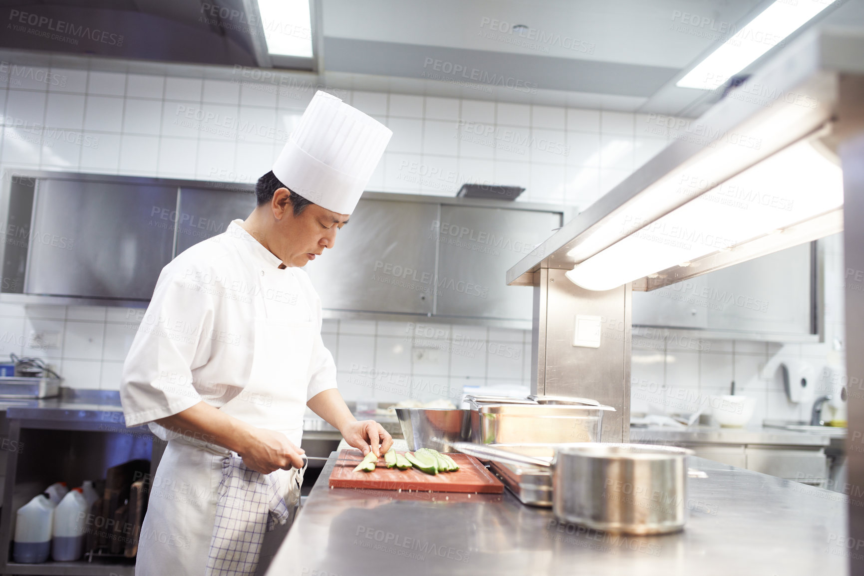 Buy stock photo Chef, man and knife in kitchen for food industry, catering service or prepare dish. Hospitality, professional and asian person cutting for cooking meal, fine dining or dinner in restaurant in China