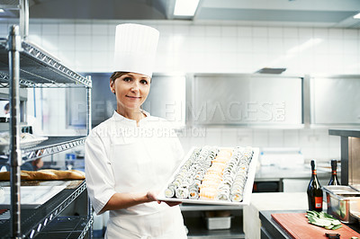 Buy stock photo Portrait of a chef holding a large platter of sushi in a restaurant kitchen