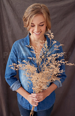 Buy stock photo Shot of a beautiful young woman holding a dried out plant