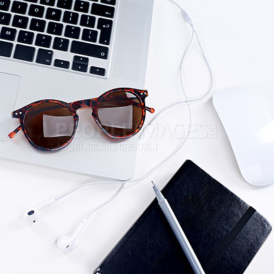 Buy stock photo Shot of a laptop, glasses, mouse and notebook on a table
