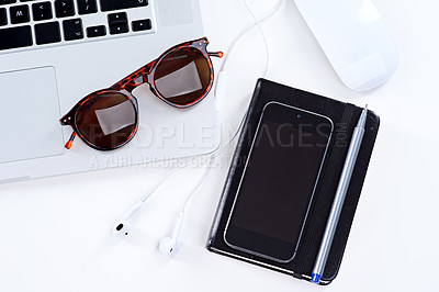 Buy stock photo Shot of a laptop, glasses, mouse and notebook on a table