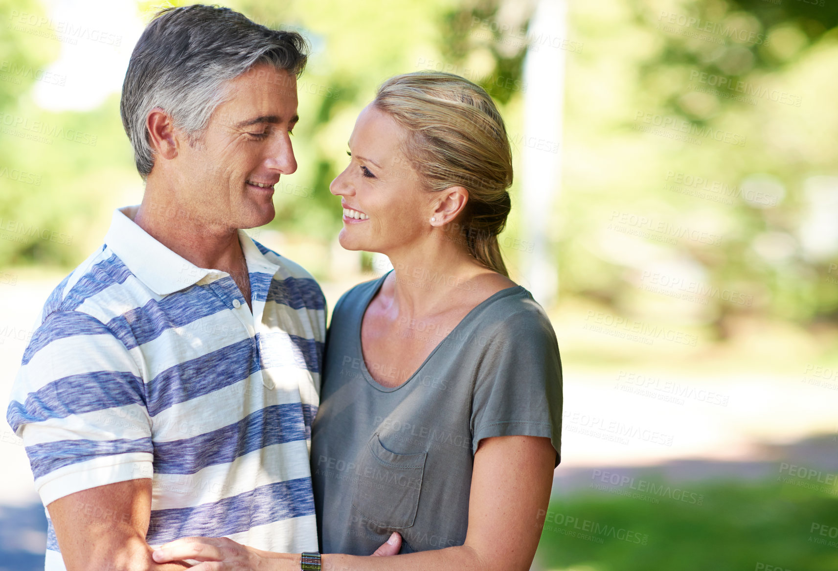 Buy stock photo Cropped shot of an affectionate mature couple enjoying a day in the park