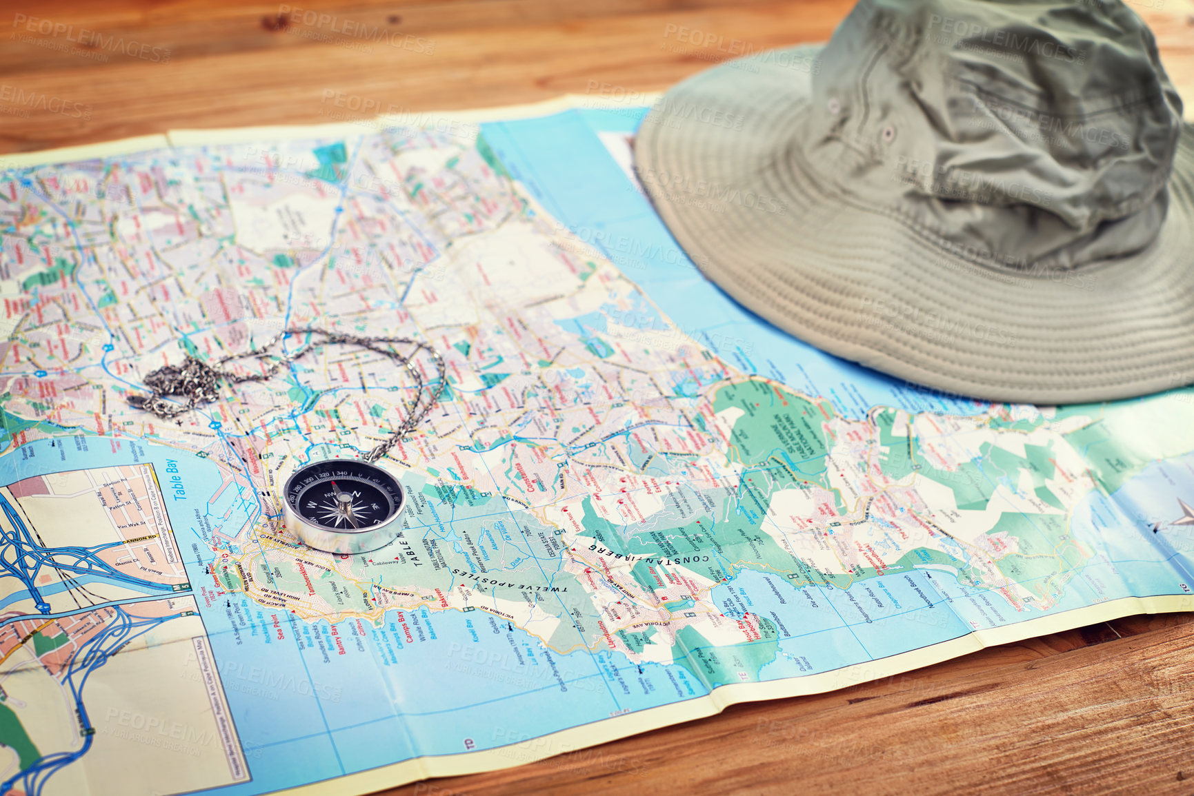 Buy stock photo Hat, map and travel guide with compass on table for itinerary schedule, adventure explore and direction. Vintage, geography and location with holiday planning for tourism, navigation and discovery