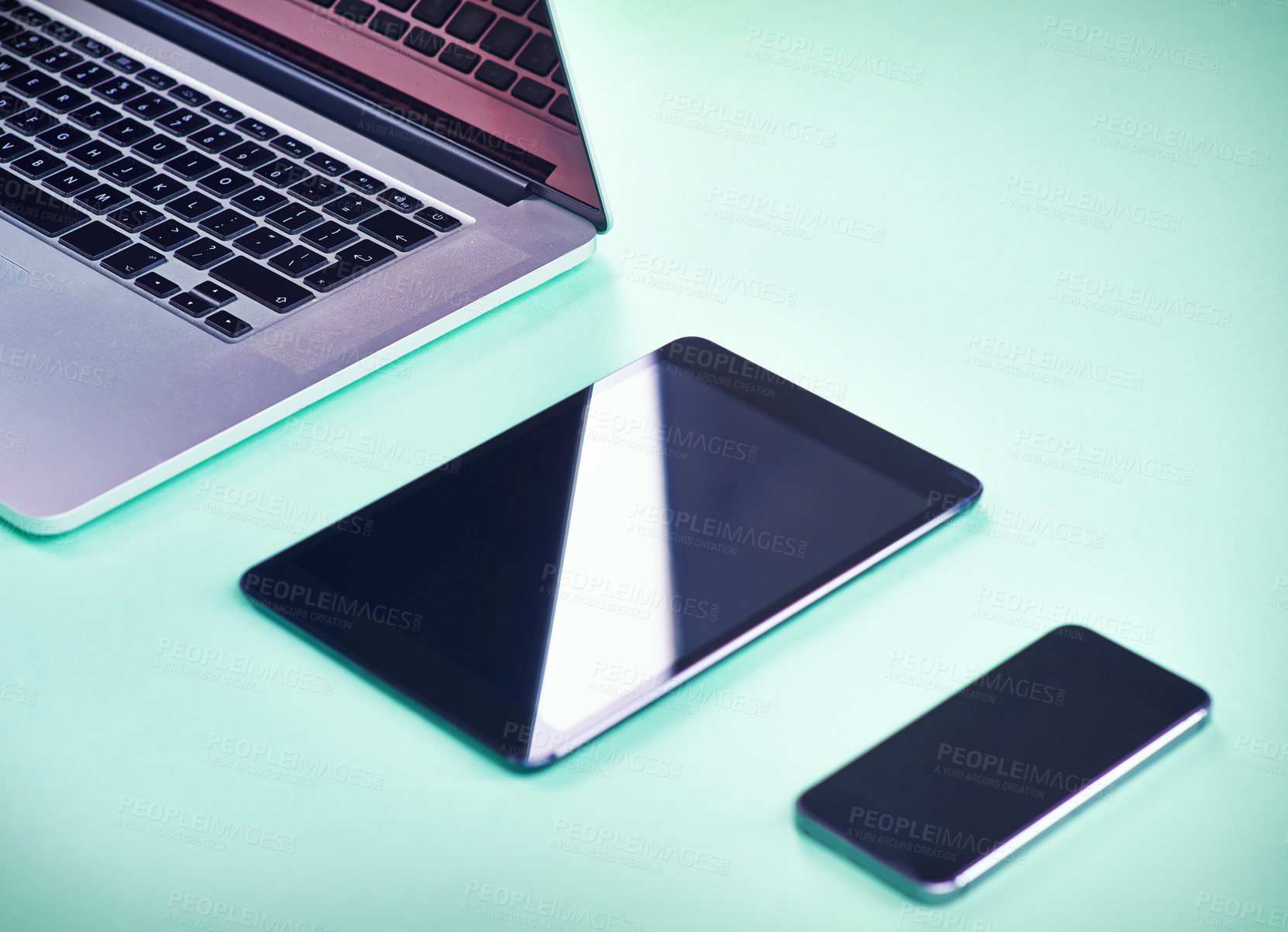 Buy stock photo Studio shot of a laptop, tablet and smartphone on a green background