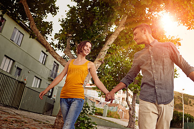 Buy stock photo Shot of a happy young couple enjoying a romantic walk together outdoors