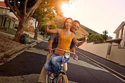 Buy stock photo Shot of a happy young couple enjoying a bicycle ride together