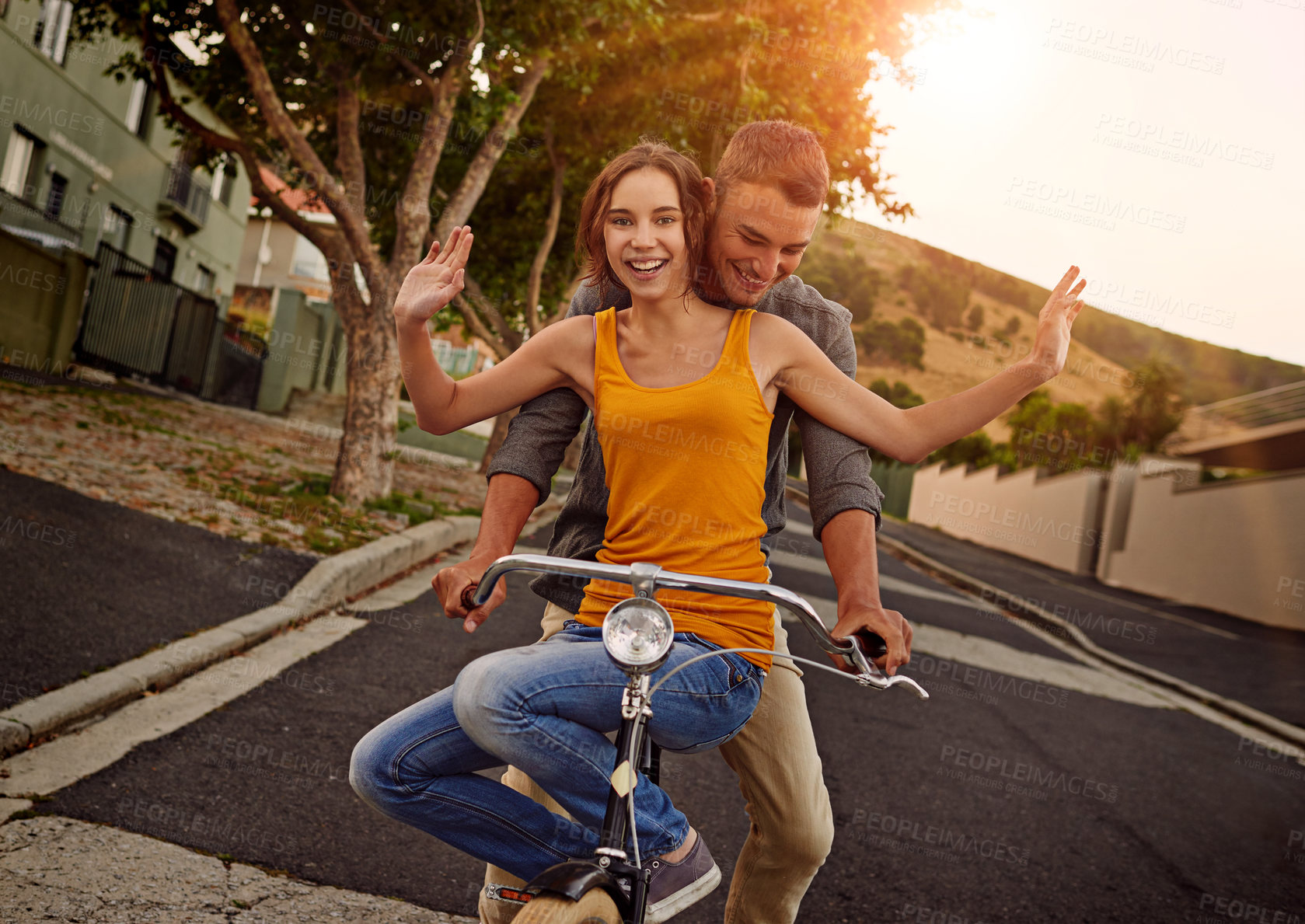 Buy stock photo Shot of a happy young couple enjoying a bicycle ride together