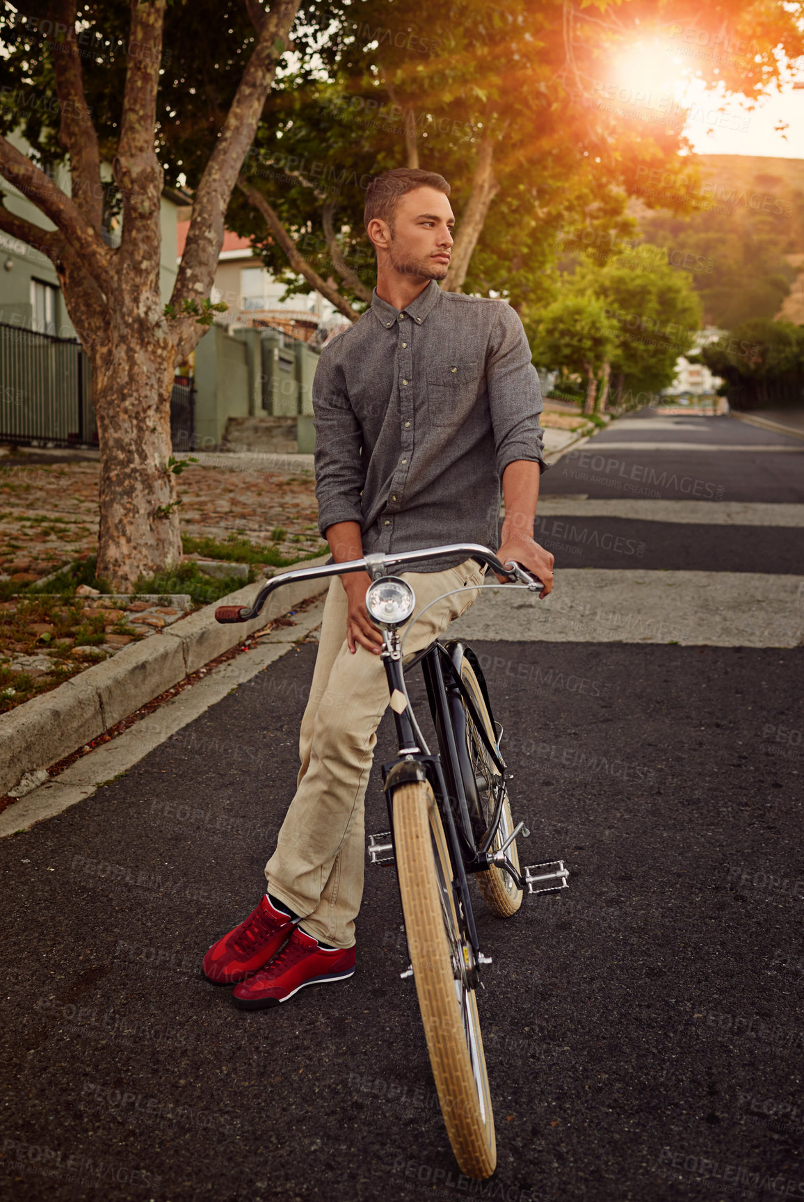Buy stock photo A young man standing with his bicycle outdoors