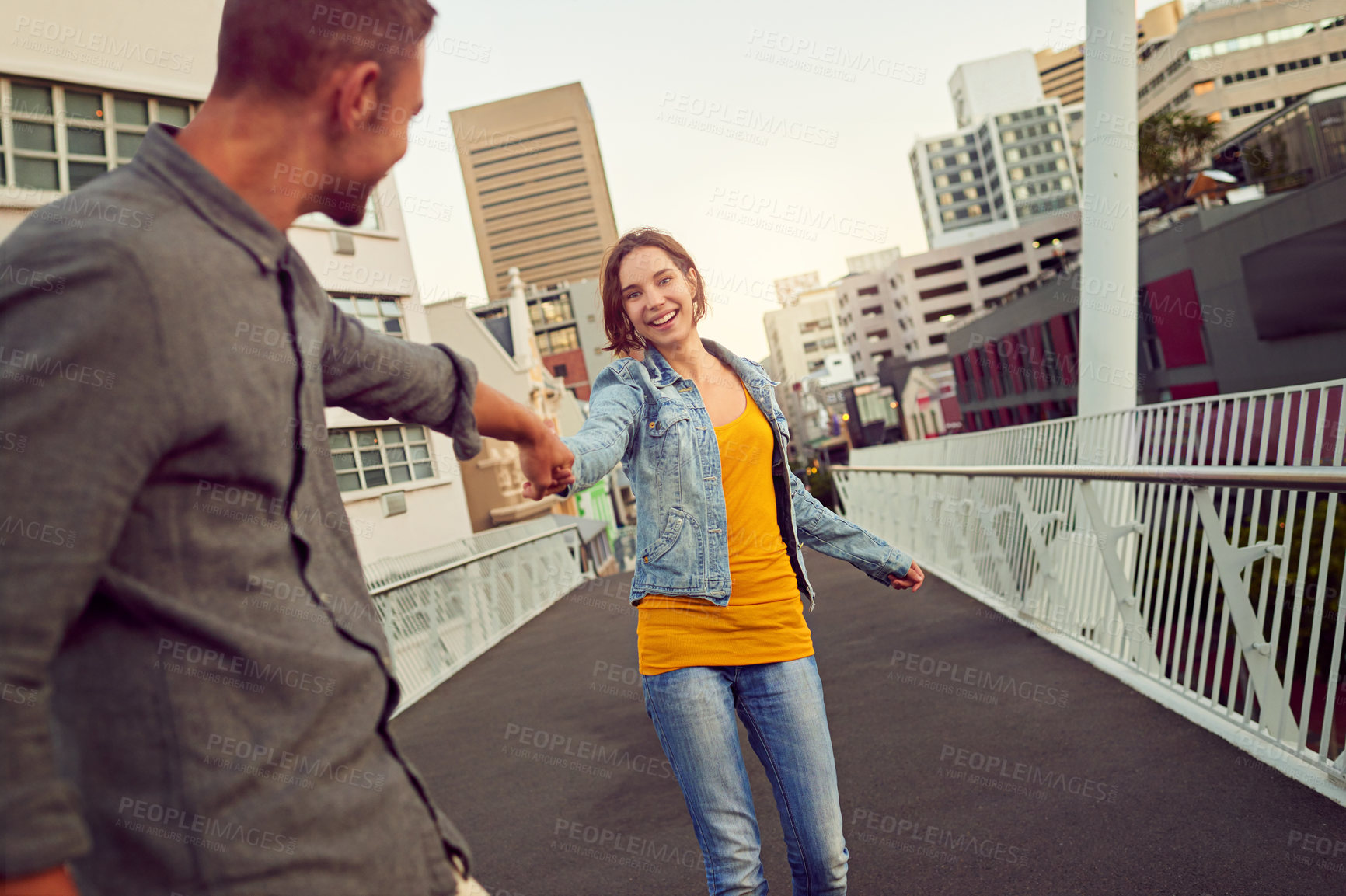 Buy stock photo Shot of a happy young couple enjoying a romantic walk together in the city