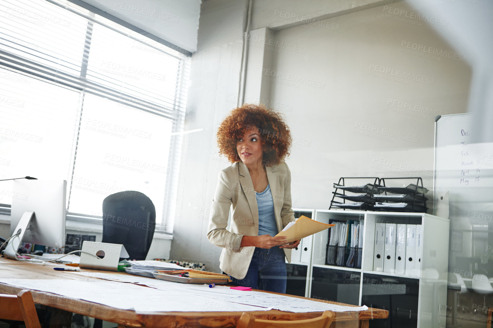 Buy stock photo Cropped shot of a beautiful young businesswoman looking over some documents in her office