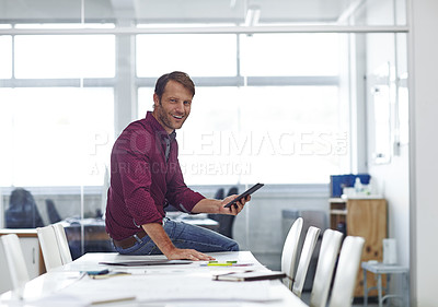 Buy stock photo Cropped shot of a handsome businessman using his tablet in the office