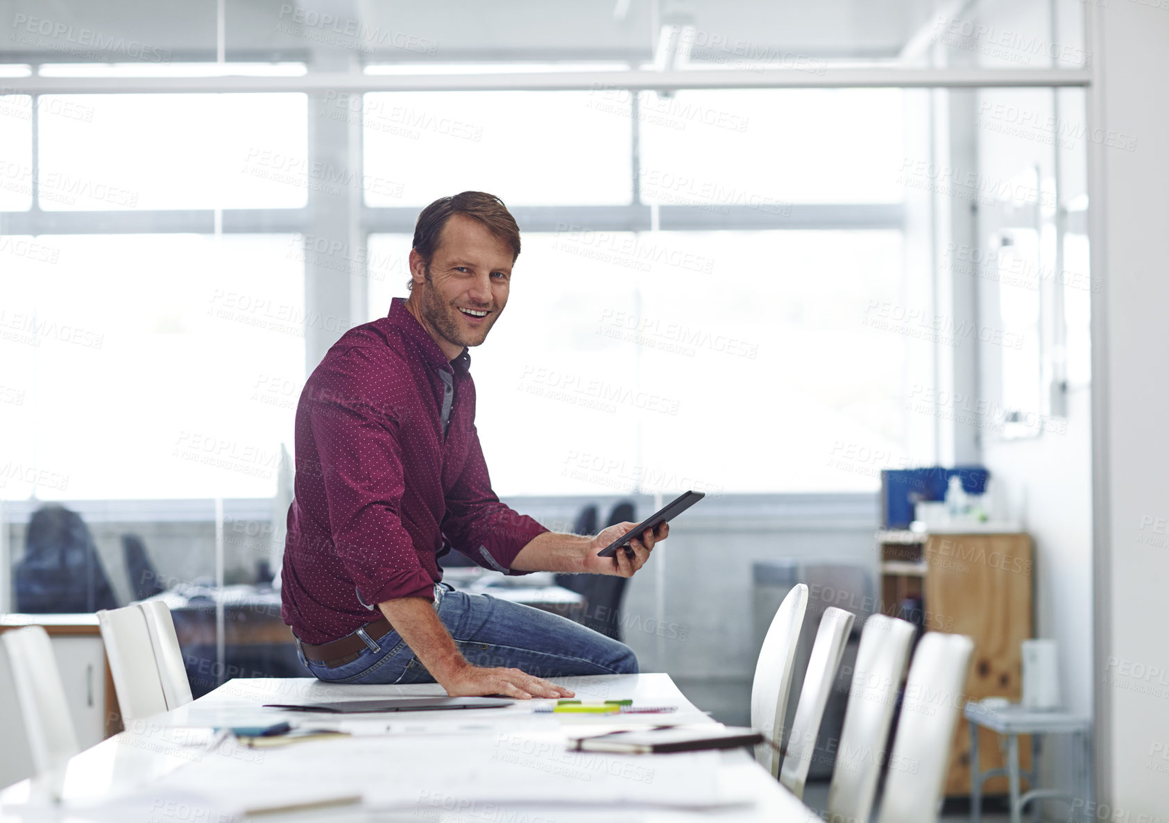 Buy stock photo Cropped shot of a handsome businessman using his tablet in the office