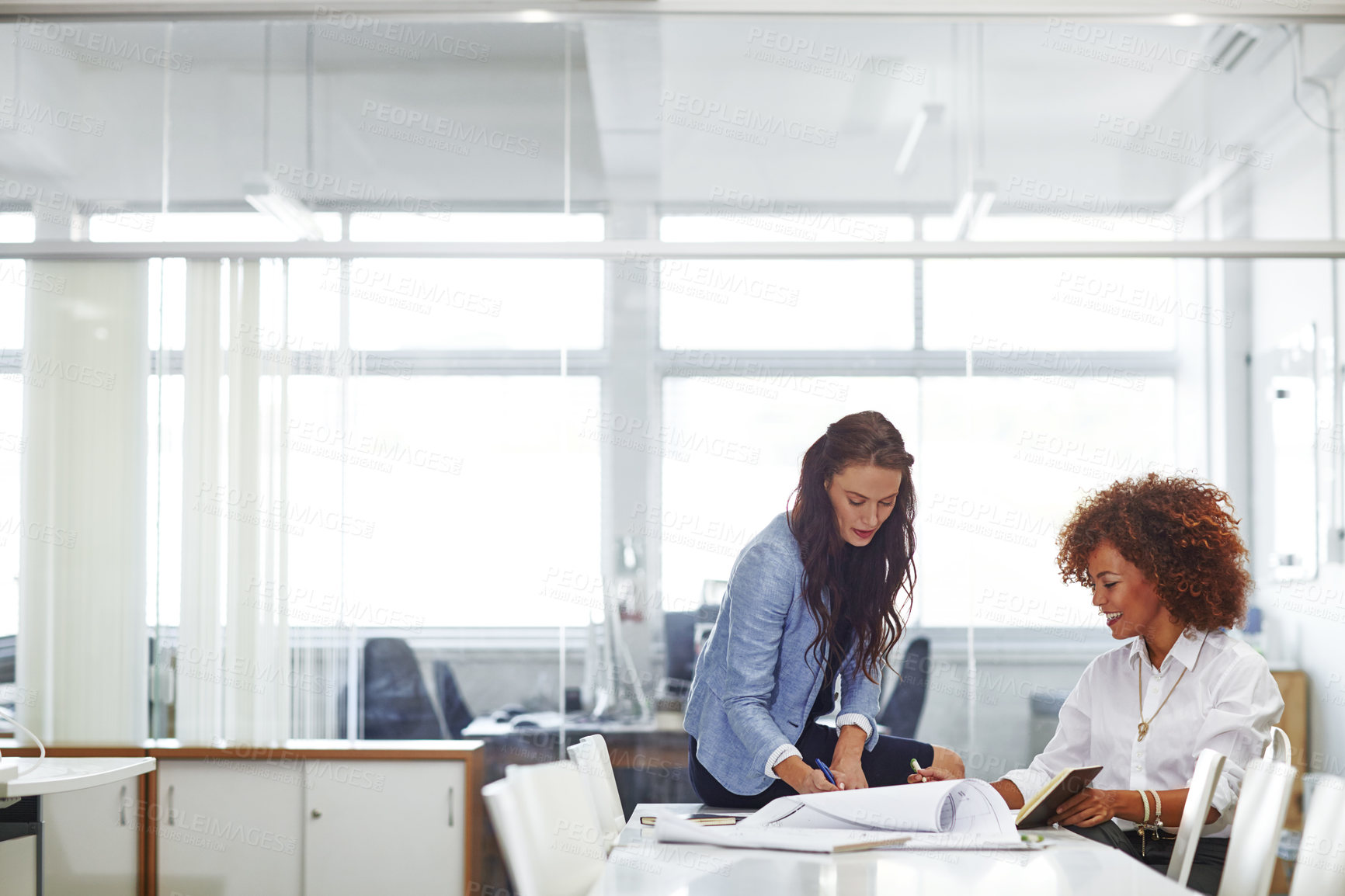 Buy stock photo Shot of two young female designers discussing work in the office